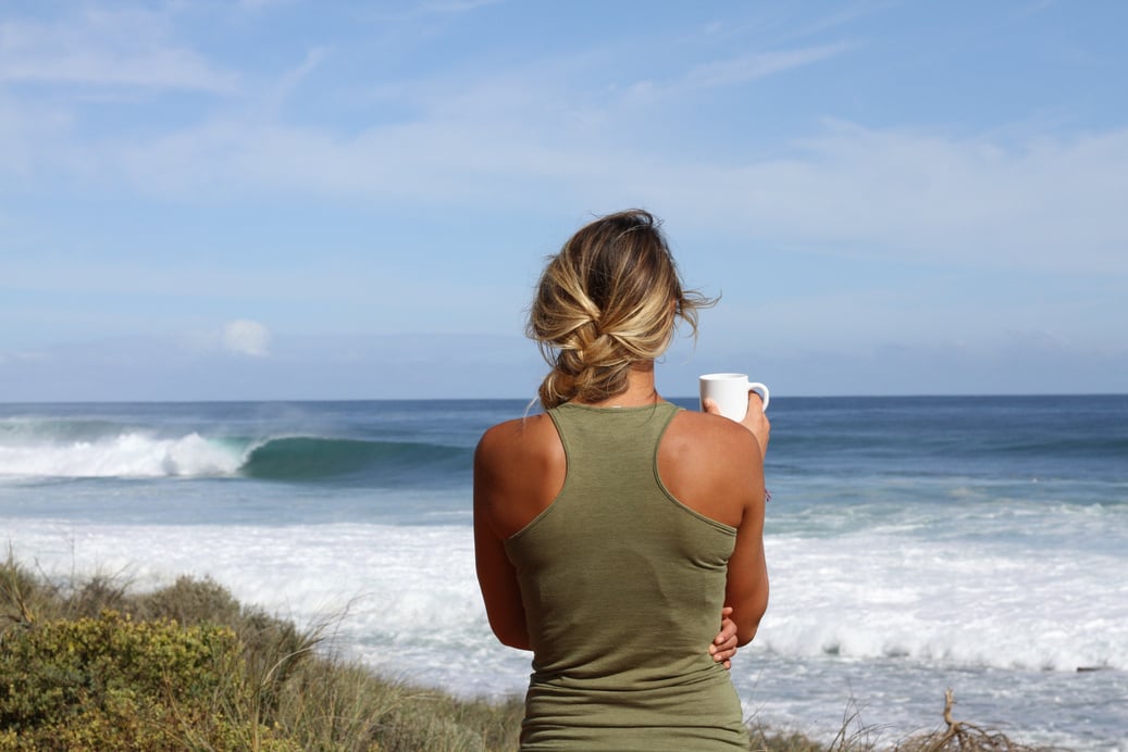 Woman Drinking Coffee by the Beach